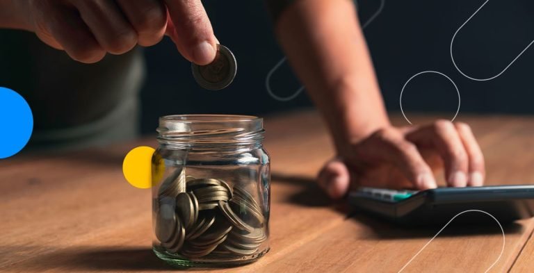 Pessoa colocando moeda em pote de vidro com mais moedas ao lado de calculadora