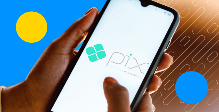 Mão segurando celular com logo do Pix na tela