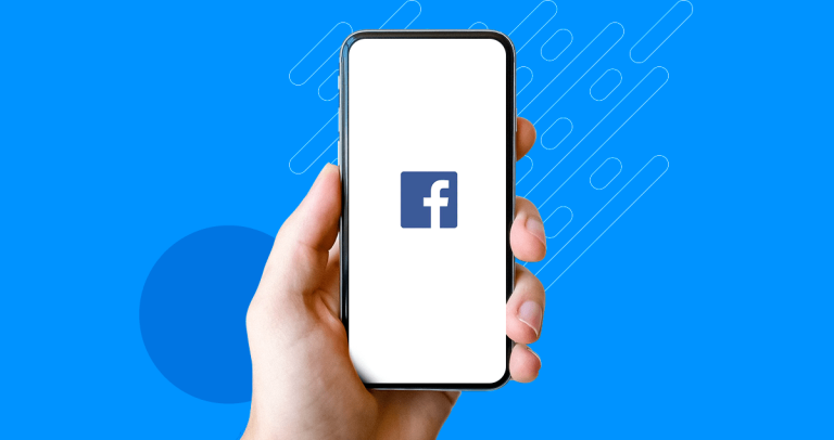 Mão segurando celular com logo do Facebook sobre fundo azul
